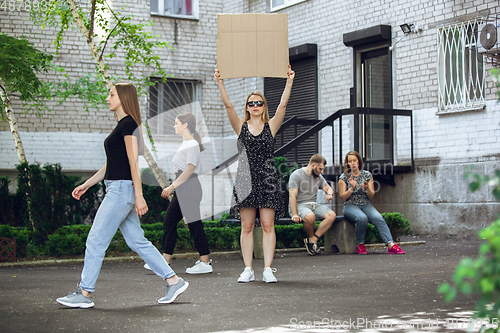 Image of Dude with sign - woman stands protesting things that annoy her