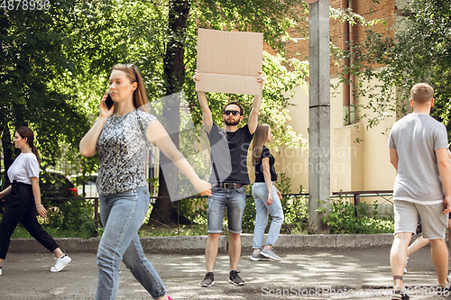 Image of Dude with sign - man stands protesting things that annoy him