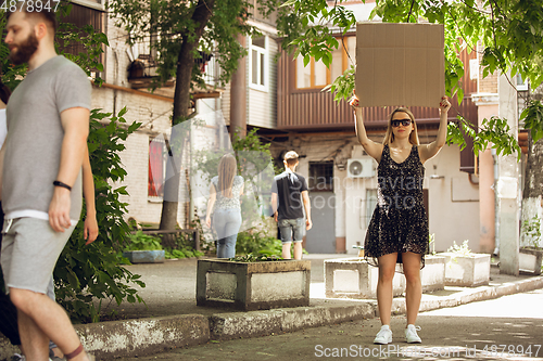 Image of Dude with sign - woman stands protesting things that annoy her