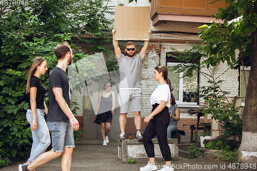 Image of Dude with sign - man stands protesting things that annoy him