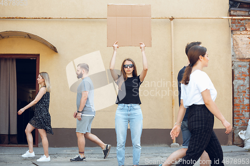 Image of Dude with sign - woman stands protesting things that annoy her