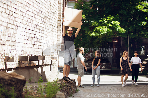 Image of Dude with sign - man stands protesting things that annoy him