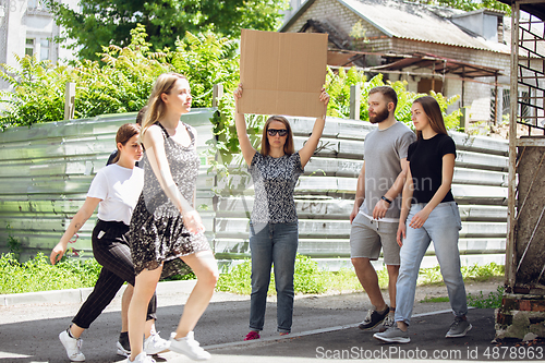 Image of Dude with sign - woman stands protesting things that annoy her