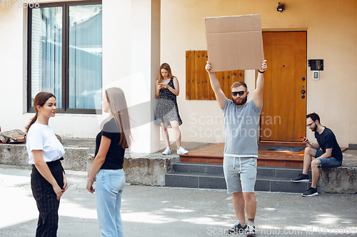 Image of Dude with sign - man stands protesting things that annoy him