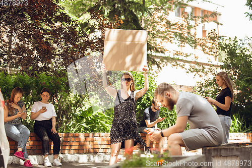 Image of Dude with sign - woman stands protesting things that annoy her