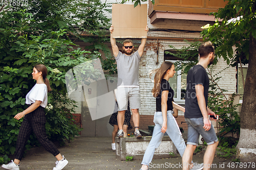 Image of Dude with sign - man stands protesting things that annoy him