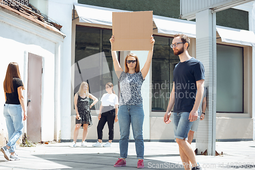 Image of Dude with sign - woman stands protesting things that annoy her