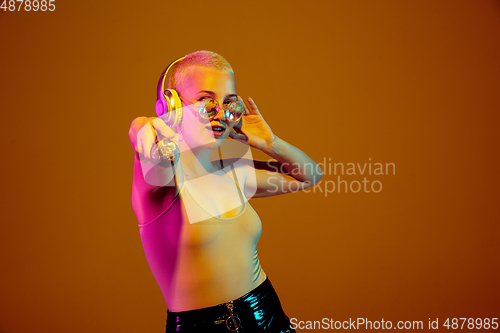 Image of Portrait of young caucasian woman in fashionable eyewear on brown background with copyspace, unusual and freaky appearance