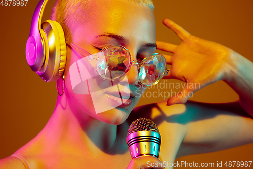 Image of Portrait of young caucasian woman in fashionable eyewear on brown background with copyspace, unusual and freaky appearance