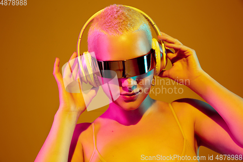 Image of Portrait of young caucasian woman in fashionable eyewear on brown background with copyspace, unusual and freaky appearance