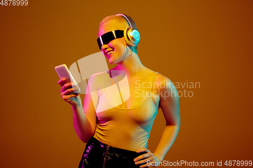 Image of Portrait of young caucasian woman in fashionable eyewear on brown background with copyspace, unusual and freaky appearance