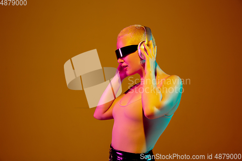 Image of Portrait of young caucasian woman in fashionable eyewear on brown background with copyspace, unusual and freaky appearance