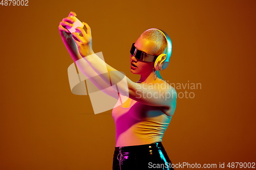 Image of Portrait of young caucasian woman in fashionable eyewear on brown background with copyspace, unusual and freaky appearance