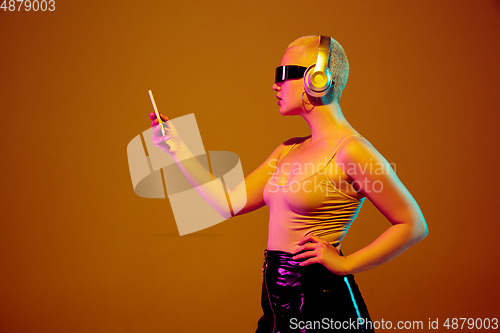 Image of Portrait of young caucasian woman in fashionable eyewear on brown background with copyspace, unusual and freaky appearance