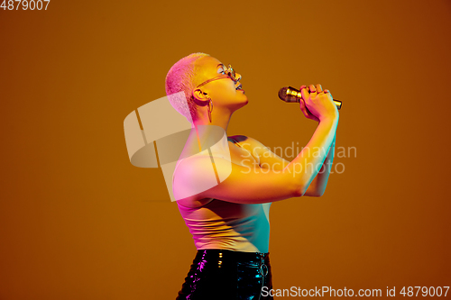 Image of Portrait of young caucasian woman in fashionable eyewear on brown background with copyspace, unusual and freaky appearance