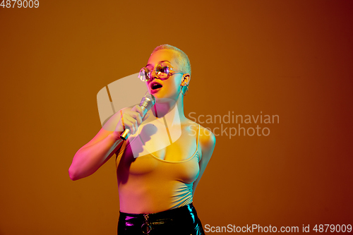 Image of Portrait of young caucasian woman in fashionable eyewear on brown background with copyspace, unusual and freaky appearance