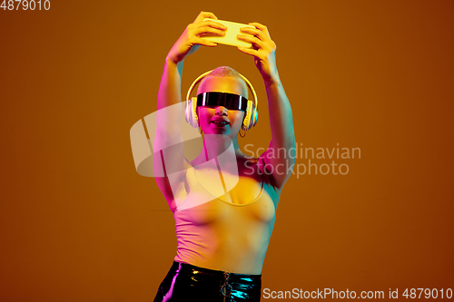 Image of Portrait of young caucasian woman in fashionable eyewear on brown background with copyspace, unusual and freaky appearance