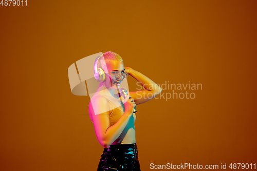 Image of Portrait of young caucasian woman in fashionable eyewear on brown background with copyspace, unusual and freaky appearance