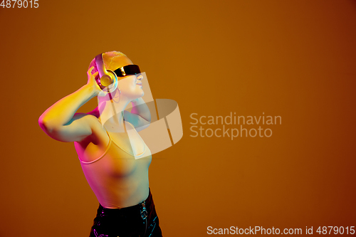 Image of Portrait of young caucasian woman in fashionable eyewear on brown background with copyspace, unusual and freaky appearance