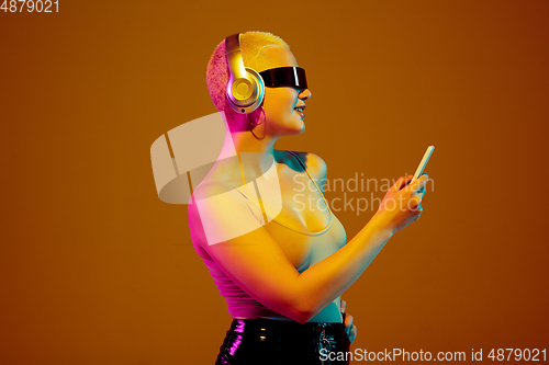 Image of Portrait of young caucasian woman in fashionable eyewear on brown background with copyspace, unusual and freaky appearance