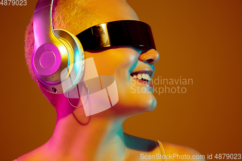 Image of Portrait of young caucasian woman in fashionable eyewear on brown background with copyspace, unusual and freaky appearance