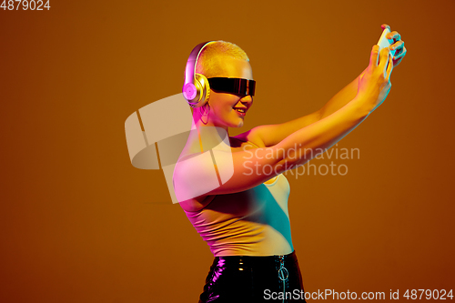 Image of Portrait of young caucasian woman in fashionable eyewear on brown background with copyspace, unusual and freaky appearance