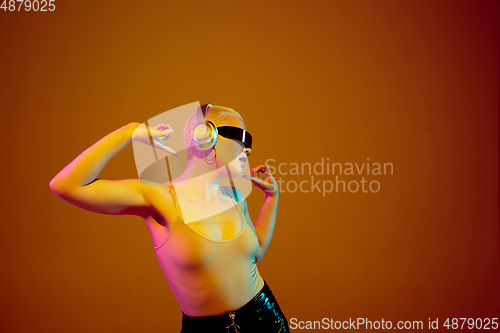 Image of Portrait of young caucasian woman in fashionable eyewear on brown background with copyspace, unusual and freaky appearance