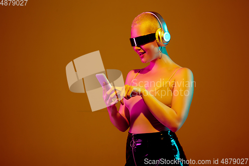 Image of Portrait of young caucasian woman in fashionable eyewear on brown background with copyspace, unusual and freaky appearance