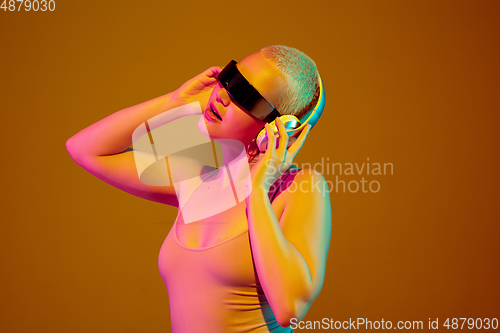 Image of Portrait of young caucasian woman in fashionable eyewear on brown background with copyspace, unusual and freaky appearance