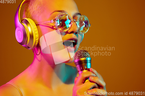 Image of Portrait of young caucasian woman in fashionable eyewear on brown background with copyspace, unusual and freaky appearance