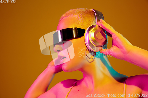 Image of Portrait of young caucasian woman in fashionable eyewear on brown background with copyspace, unusual and freaky appearance