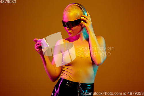 Image of Portrait of young caucasian woman in fashionable eyewear on brown background with copyspace, unusual and freaky appearance