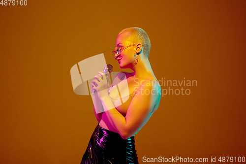 Image of Portrait of young caucasian woman in fashionable eyewear on brown background with copyspace, unusual and freaky appearance