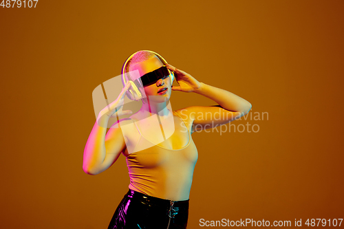 Image of Portrait of young caucasian woman in fashionable eyewear on brown background with copyspace, unusual and freaky appearance