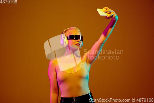 Image of Portrait of young caucasian woman in fashionable eyewear on brown background with copyspace, unusual and freaky appearance