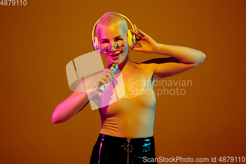 Image of Portrait of young caucasian woman in fashionable eyewear on brown background with copyspace, unusual and freaky appearance