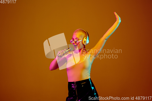 Image of Portrait of young caucasian woman in fashionable eyewear on brown background with copyspace, unusual and freaky appearance