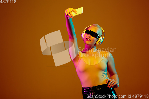 Image of Portrait of young caucasian woman in fashionable eyewear on brown background with copyspace, unusual and freaky appearance