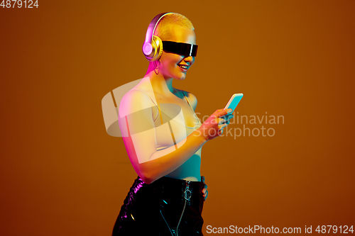 Image of Portrait of young caucasian woman in fashionable eyewear on brown background with copyspace, unusual and freaky appearance