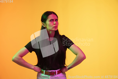 Image of Caucasian young woman\'s portrait on yellow background in neon light