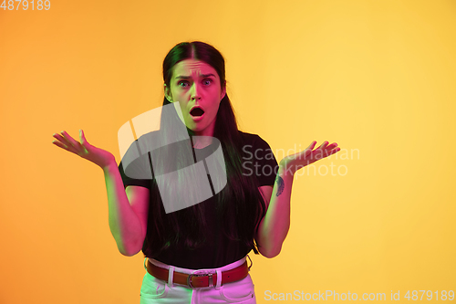 Image of Caucasian young woman\'s portrait on yellow background in neon light