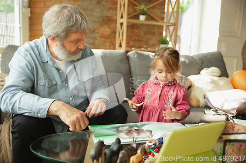 Image of Grandfather and child playing together at home. Happiness, family, relathionship, education concept.