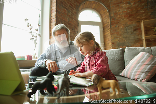 Image of Grandfather and child playing together at home. Happiness, family, relathionship, education concept.