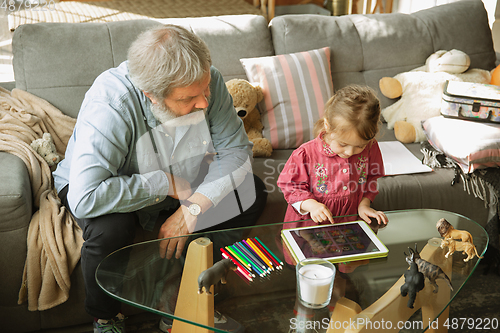 Image of Grandfather and child playing together at home. Happiness, family, relathionship, education concept.