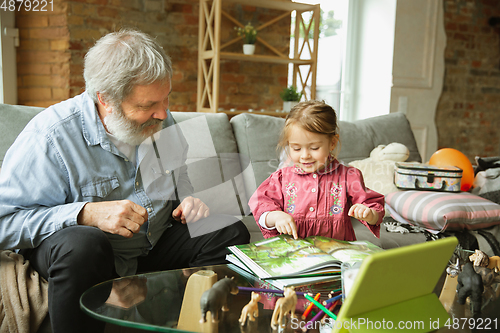 Image of Grandfather and child playing together at home. Happiness, family, relathionship, education concept.