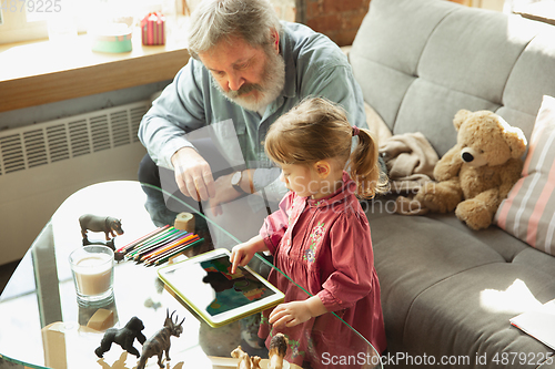 Image of Grandfather and child playing together at home. Happiness, family, relathionship, education concept.