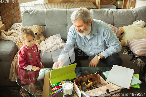 Image of Grandfather and child playing together at home. Happiness, family, relathionship, education concept.