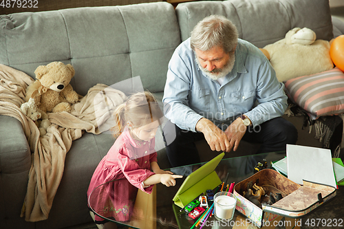 Image of Grandfather and child playing together at home. Happiness, family, relathionship, education concept.