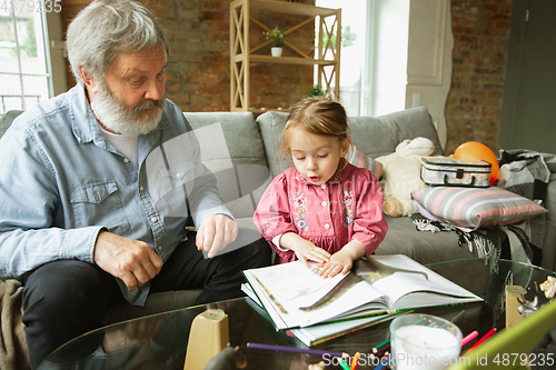 Image of Grandfather and child playing together at home. Happiness, family, relathionship, education concept.