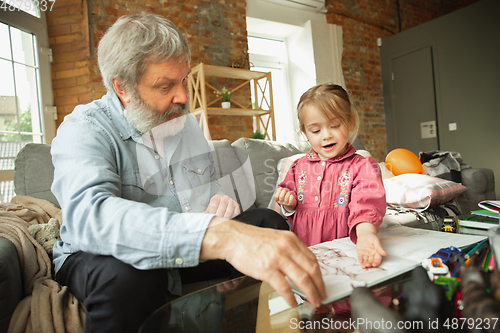 Image of Grandfather and child playing together at home. Happiness, family, relathionship, education concept.